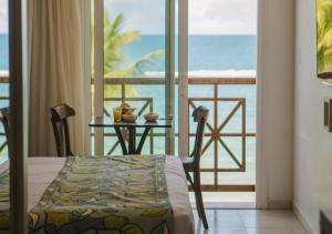a room with a table and a view of the ocean at Hotel Ponta Verde Praia do Francês in Praia do Frances