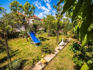 ein blauer Stuhl und ein Vogel im Hof in der Unterkunft Apartments Amalia in Zadar