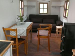 uma sala de estar com uma mesa e cadeiras e um sofá em Bauwagen unterm Birnbaum em Lennestadt