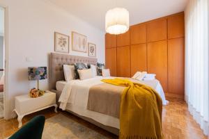 um quarto com uma cama grande com um cobertor amarelo em Maria Home Reall's em Braga