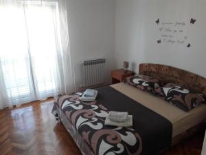 ein Schlafzimmer mit einem Bett mit einer schwarzen und braunen Decke in der Unterkunft Apartments Amalia in Zadar