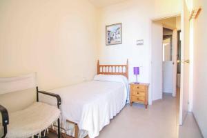 ein Schlafzimmer mit einem Bett, einem Tisch und einem Stuhl in der Unterkunft Apartamento con vistas al mar - Anfiteatro 18 in Calpe