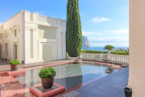 ein weißes Haus mit einem Swimmingpool direkt am Meer in der Unterkunft Apartamento con vistas al mar - Anfiteatro 18 in Calpe