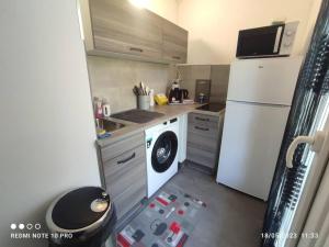cocina pequeña con lavadora y nevera en Appartement déplacement Quartier Victor Hugo, en Nevers