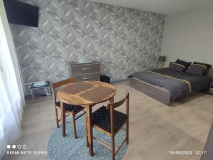 1 dormitorio con mesa, sillas y 1 cama en Appartement déplacement Quartier Victor Hugo, en Nevers