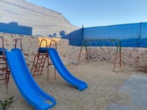 a playground with a blue slide in the sand at Blue Diamond in Jerash
