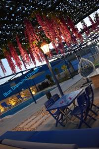 a table and chairs in front of a building with lights at Blue Diamond in Jerash