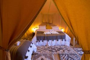 a bedroom with two beds in a tent at Horaz Merzouga Camp in Merzouga