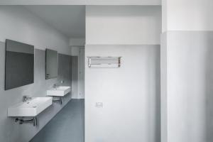 a bathroom with two sinks and two mirrors at OSTELLO HENRY in Buggerru