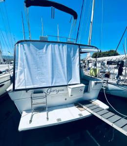 a boat with a chair sitting on a dock at Giorgia House Boat in Palermo