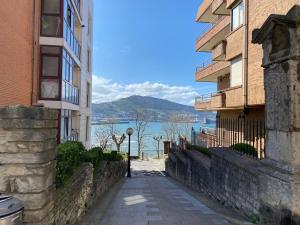 an alley way between two buildings with a view of the water at Getxo Beach Apartment by Getxo Garden Houses in Getxo