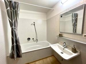 a white bathroom with a tub and a sink at Entire Apartment, near Clarion, O2 Arena, Metro 3 min, Easter market in City Center 15 min in Prague +25 photos