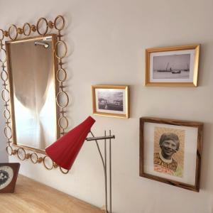 un miroir et une lampe sur un mur avec des photos dans l'établissement Jaffa Seaside House, à Tel Aviv