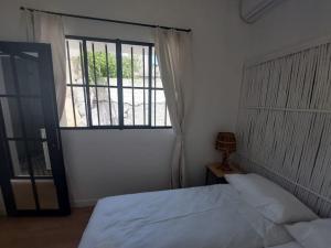 a bedroom with a bed and a large window at Dar Zwina, Charming and lovely house in Tangier