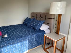 a small bedroom with a bed and a lamp at Hotel APART Zuccolotto 303 in Aracruz