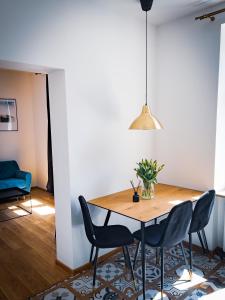 a dining room with a wooden table and chairs at Black&White Apartment 8 in Katowice