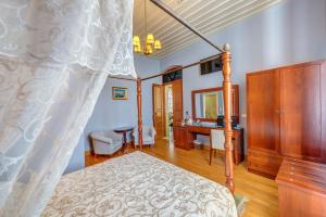 a bedroom with a canopy bed and a desk at Apollonion Palace in Ermoupoli