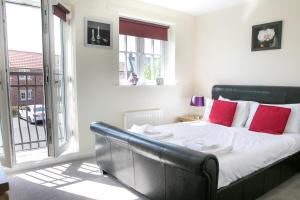 a bedroom with a large bed with red pillows at The Bay Filey in Filey