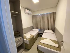 een kleine kamer met twee bedden en een raam bij Edifício Promenade II Apto 1106-Mandi Hospitalidade in Maceió +21 foto's