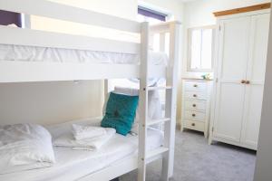 1 dormitorio con 2 literas y almohada azul en The Bay Filey en Filey