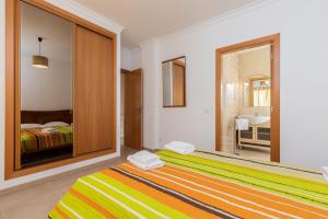 een slaapkamer met een groot bed en een spiegel bij Villa Amarela by AlgarveManta in Manta Rota