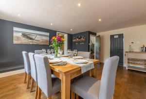 a dining room with a wooden table and chairs at Heath Cottage in Mattishall