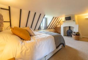 a bedroom with a king sized bed with a fireplace at Heath Cottage in Mattishall