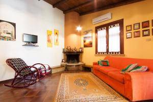 a living room with a orange couch and a fireplace at Villino Dei Gabbiani in Castellammare del Golfo