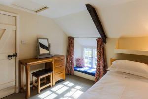 a bedroom with a bed and a desk with a television at South Priddacombe - Bolventor Cornwall in Launceston