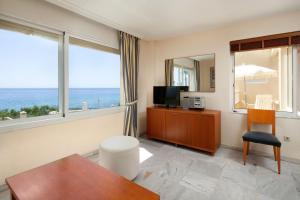 a living room with a television and a large window at Pueblo Marina Seaside Apartaments by Alfresco Stays in Mijas Costa