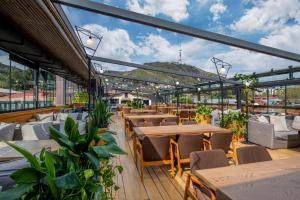 a restaurant with tables and chairs and windows at IOTA Hotel Tbilisi in Tbilisi City