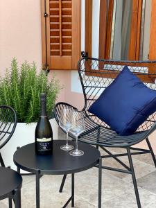 a bottle of wine on a table with a wine glass at Libertas apartments in Koper
