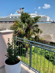 a palm tree on a balcony with a cruise ship at Libertas apartments in Koper