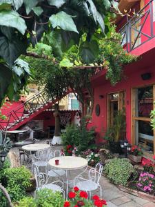 un groupe de tables et de chaises devant un bâtiment dans l'établissement Red Goat Hostel, à Tirana