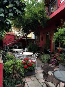 an outdoor patio with tables and chairs and flowers at Red Goat Hostel in Tirana