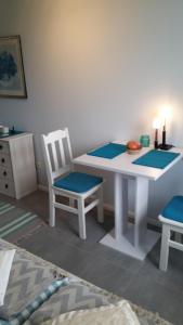 a white table with two chairs and a white table with blue mats at Scharbeutz! Bed & Breakfast, eig. Bad, Terrasse, veg./veganem Frühst., Allergiker in Scharbeutz
