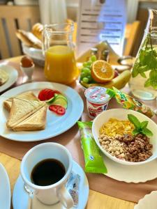 a table topped with plates of food and a cup of coffee at Penzión Tiberia in Trenčín