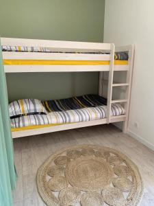 - 2 lits superposés dans une chambre avec un tapis dans l'établissement Appt avec vue mer exceptionnelle, à Guidel
