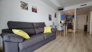 sala de estar con sofá gris y almohadas amarillas en CALA ALTA sun&beach apartaments, en Cala de Finestrat