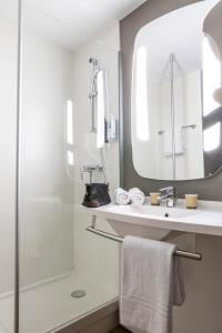 ein Bad mit einer Dusche, einem Waschbecken und einem Spiegel in der Unterkunft ibis Paris Creteil in Créteil