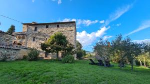 an old stone building with chairs in a yard at Colle del Vento in Todi