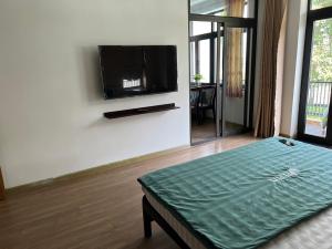 a living room with a flat screen tv on a wall at PUPON Homestay and Coffee in Quang Ngai