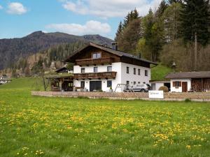 ein Haus mit einem grünen Feld davor in der Unterkunft Ferienwohnung Waldesruh in Kössen