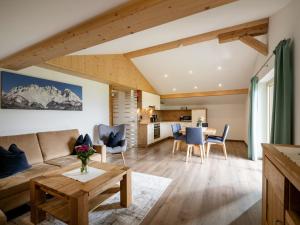 ein Wohnzimmer mit einem Sofa und einem Tisch in der Unterkunft Ferienwohnung Waldesruh in Kössen