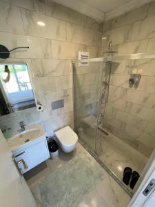 a bathroom with a shower and a toilet and a sink at Airport Guest House in Dalaman