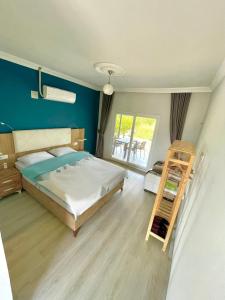 1 dormitorio con 1 cama con pared azul en Airport Guest House, en Dalaman