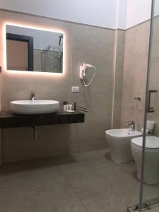 W łazience znajduje się umywalka, toaleta i lustro. w obiekcie Perla D'Oriente w mieście Otranto