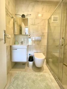 uma casa de banho com um chuveiro, um WC e um lavatório. em Airport Guest House em Dalaman
