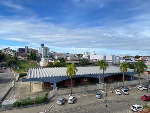 a building with cars parked in a parking lot at Hotel APART Zuccolotto 303 in Aracruz