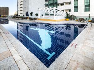 a swimming pool with a sign in the water at Flat Hotel Mercure - Centro de Brasília A012 in Brasilia